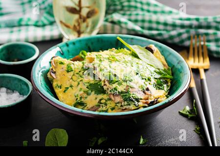 Spinaci e frittata di funghi. Frittata composta da uova, funghi e spinaci. Cucina italiana. Foto Stock