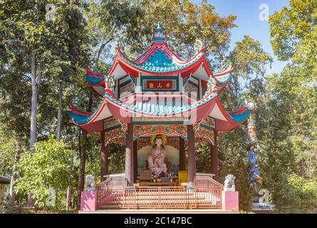 Phayao, Thailandia - 8 dicembre 2019: Statua di Guanyin nel Santuario del Tempio Tailandese di Analayo con luce naturale su cielo blu e sfondo della foresta Foto Stock