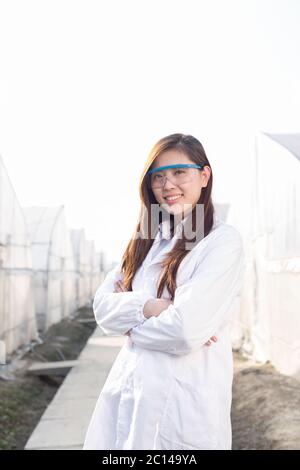 Giovane bella donna asiatica lavora nel campo verde Foto Stock