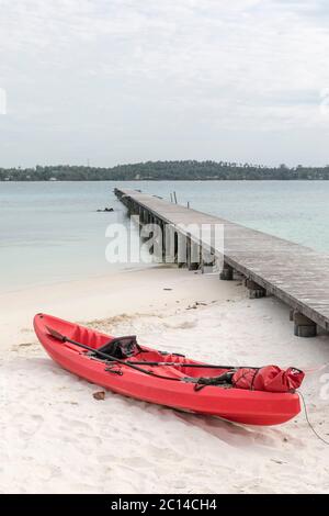 Canoa rossa e molo di legno, isola di koh kham, Thailandia. Foto Stock