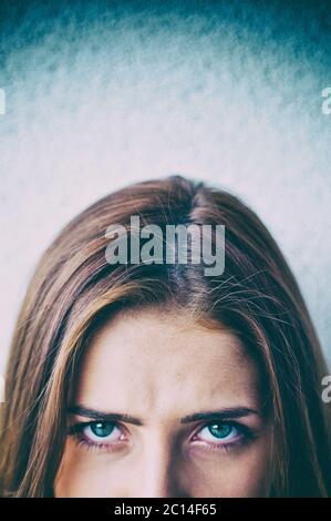 mezza faccia di una giovane donna che guarda con uno sguardo intenso Foto Stock