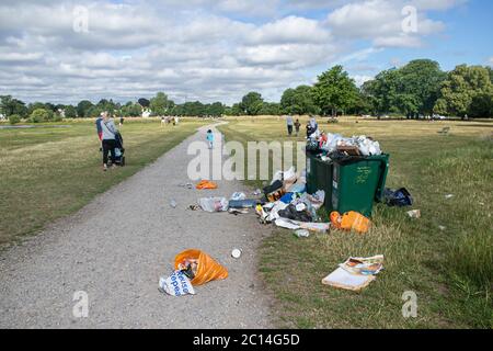 WIMBLEDON LONDRA, REGNO UNITO. 14 giugno 2020. I bidoni dei rifiuti sono riempiti con molti articoli di spazzatura su Wimbledon Common, tra cui sacchetti di plastica, scatole di pizza vuote, bottiglie di birra e lattine lasciate dietro, mentre la gente approfitta del tempo caldo all'aperto durante l'allentamento del coronavirus blocco. Credit: amer Ghazzal/Alamy Live News Foto Stock