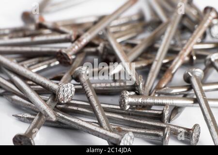 Stirare chiodi arrugginiti su uno sfondo bianco Foto Stock