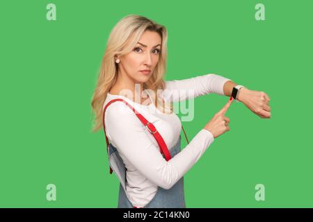 È tardi, è il momento di andare! Ritratto di donna adulta bossy Strict in tute  eleganti che puntano all'orologio da polso e che guarda con espressi  impazienti dispiaciuti Foto stock - Alamy