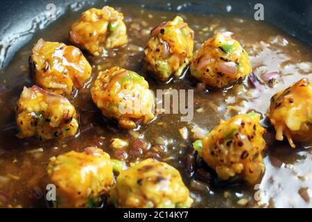 Palle vegetariane cucinando con sugo di Manchurian Foto Stock