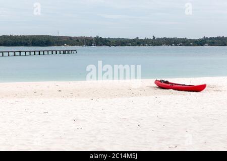 Canoa rossa e molo di legno, isola di koh kham, Thailandia. Foto Stock