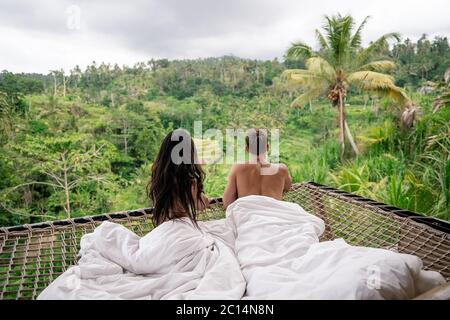 Coppia godendo di vacanze mattutine su bungalow di ville tropicali in stile palme, rilassante vacanza a Bali, Indonesia. Coppia in luna di miele. Foto Stock