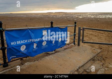 West Kirby, UK: 3 giugno 2020: Un grande banner all'ingresso della spiaggia avverte che a causa della pandemia di Corona Virus, non ci sono bagnini in servizio. Foto Stock