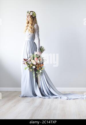 Ritratto di bellezza primaverile di una sposa con una corona e un bouquet in mano Foto Stock