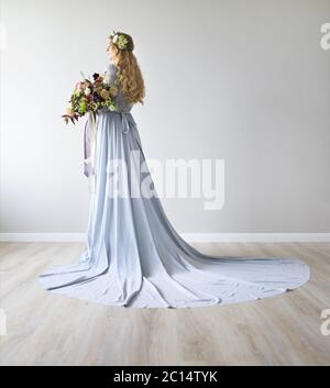 Ritratto di primavera di una sposa con una corona e un bouquet in mani Foto Stock