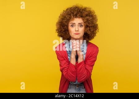 Prego, sto pregando perdonare! Ritratto di donna preoccupata sconvolto con capelli ricci che guarda con implorare disperato grimace e pregare per l'aiuto, chiedendo Apo Foto Stock