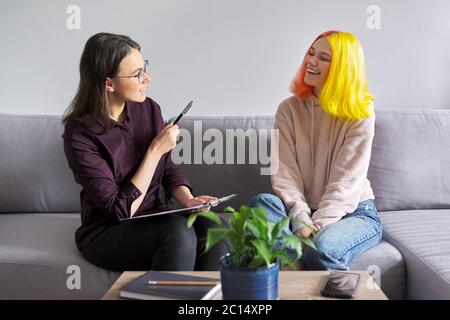 Ragazza teen che dà l'intervista al lavoratore sociale. Psicologo scolastico che parla con lo studente Foto Stock