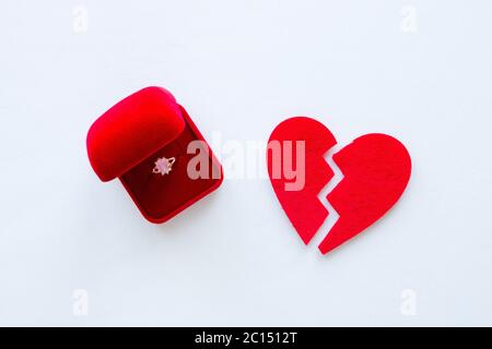 cuore rotto e un anello di nozze su sfondo bianco Foto Stock