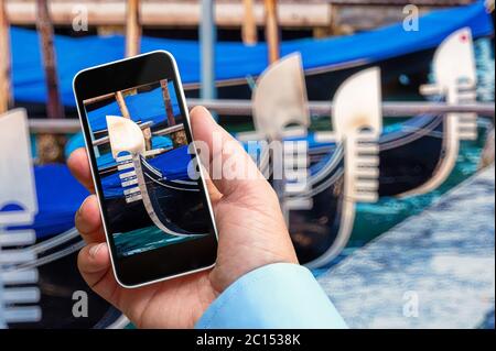 Uomo che prende una foto di un closeup di una gondola con il suo smartphone in mano Foto Stock