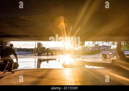 Vienna: skatepark sotto il ponte Reichsbrücke a CopaBeach, skateboarder, tramonto, puddle a causa di un drenaggio non funzionante nel 22. Donaustadt, Wien, Foto Stock