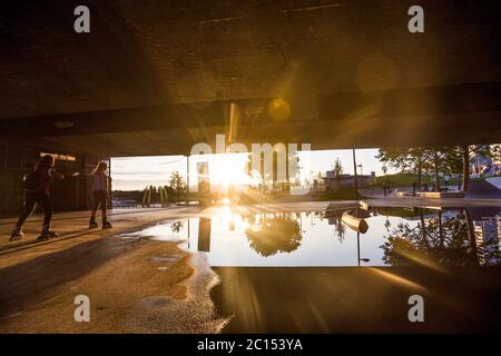 Vienna: skatepark sotto il ponte Reichsbrücke a CopaBeach, skater inline, tramonto, puddle a causa di un drenaggio non funzionante nel 22. Donaustadt, Wien, Foto Stock