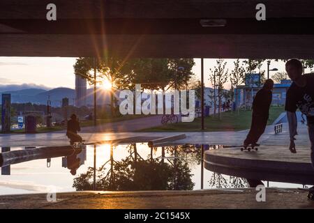 Vienna: skatepark sotto il ponte Reichsbrücke a CopaBeach, skateboarder, tramonto, puddle a causa di un drenaggio non funzionante nel 22. Donaustadt, Wien, Foto Stock