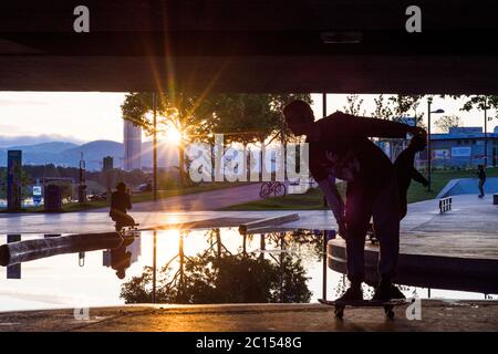 Vienna: skatepark sotto il ponte Reichsbrücke a CopaBeach, skateboarder, tramonto, puddle a causa di un drenaggio non funzionante nel 22. Donaustadt, Wien, Foto Stock