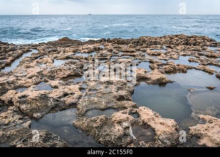 Costa rocciosa nel porto di Batroun città nel nord del Libano e una delle città più antiche del mondo Foto Stock