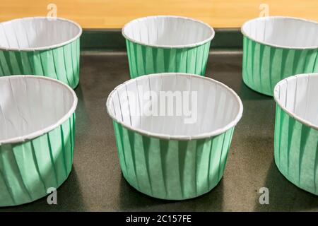 Casse per torte su una griglia da forno pronte da riempire con la pastella per cuocere in forno Foto Stock