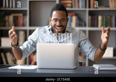 Un ragazzo africano che guarda lo schermo del pc si sente scioccato Foto Stock