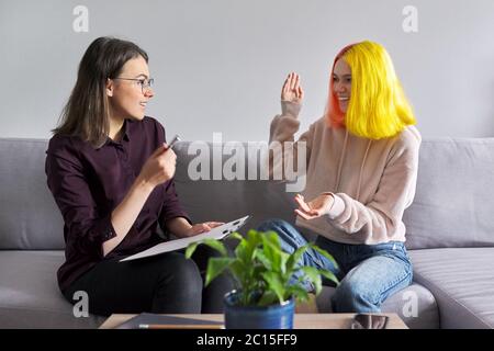 Ragazza teen che dà l'intervista al lavoratore sociale. Psicologo scolastico che parla con lo studente Foto Stock