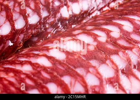 Vista dall'alto di salumi di maiale affumicati salumi chorizo fette di sfondo. Salsiccia di salame affumicata cruda Foto Stock
