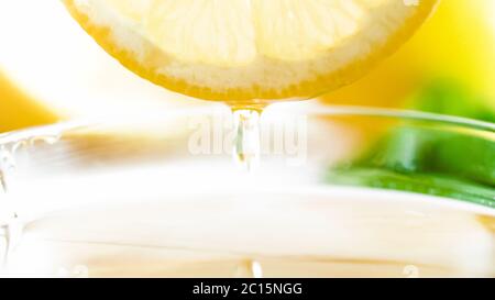 Immagine macro di gocce di miele che cadono dalla fetta di limone tagliata Foto Stock