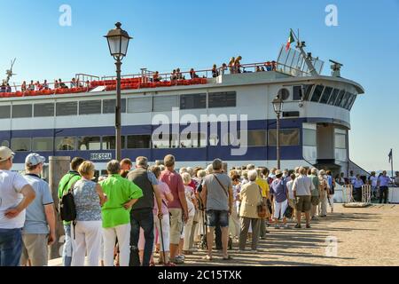 GARDA, ITALIA - SETTEMBRE 2018: Lunga coda di passeggeri in attesa di imbarcarsi su un traghetto passeggeri di grandi dimensioni a Garda sul Lago di Garda. Foto Stock