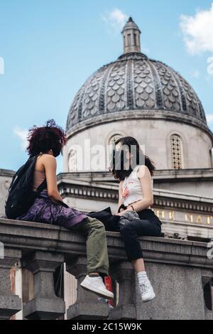 Londra / UK - 06/13/2020: La protesta contro la questione delle vite nere durante la pandemia di coronavirus. Due ragazze bianche che si siedono sul balcone di Trafalgar Square Foto Stock