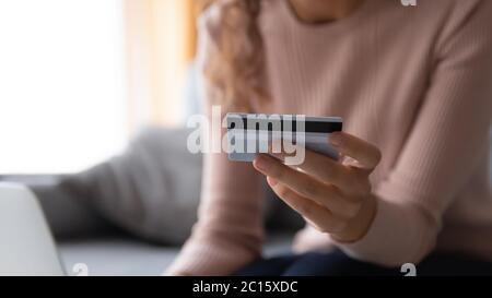 Primo piano donna che paga online, tenendo carta di credito in plastica Foto Stock