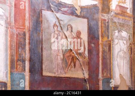 Affresco decorato nel quarto stile che mostra Ercole che si erge accanto a Juno e Minerva. Collegio dei Augustales, antica città di Ercolano Foto Stock