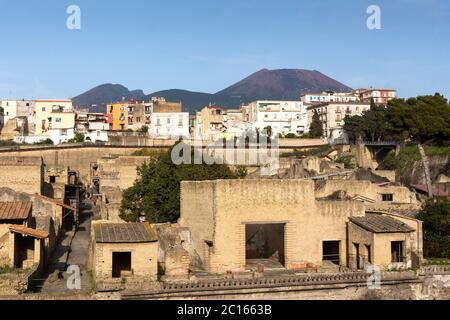 Una vista aerea attraverso le rovine romane e gli scavi dell'antica città di Ercolano (Ercolano) con il vulcano Vesuvio, Campania, Italia Foto Stock