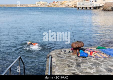 I residenti locali hanno la spiaggia a se stessi come il tempo si fa salire per l'estate. Il nuotatore in acqua aperta entra in mare. Fase 3 de-escalation del co Foto Stock