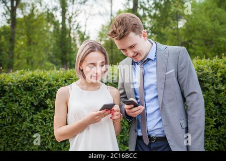 Conoscitanceship. Giovane donna e uomo che danno numeri di telefono cellulare l'uno all'altro Foto Stock