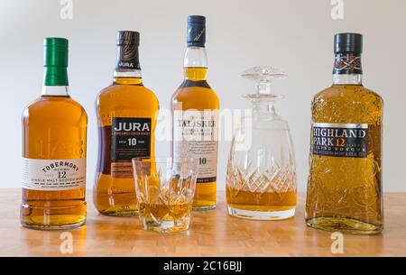 Bottiglie di whisky di malto Scotch, decanter di cristallo e bicchiere di whisky: Whisky Tobermory, whisky Jura, Taiisker & Highland Park Viking Honor whisky Foto Stock