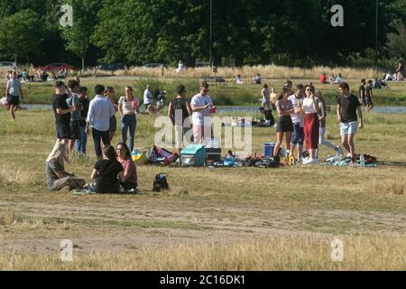 WIMBLEDON LONDRA, REGNO UNITO. 14 giugno 2020. Wimbledon Common è affollato con persone che godono il caldo sole del pomeriggio all'aperto dopo le restrizioni di blocco sono stati attenuati dal governo che consente alle persone di riunirsi all'aperto, a condizione che le persone si tengono alle linee guida di allontanamento sociale. Credit: amer Ghazzal/Alamy Live News Foto Stock