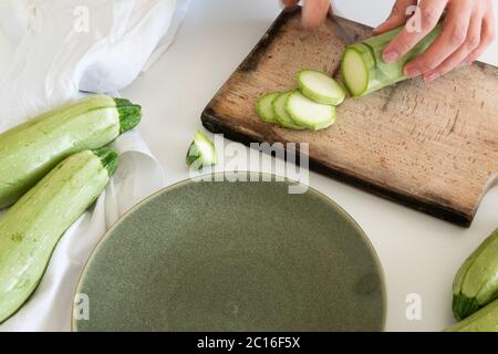 Vista superiore della donna mani preparare freschi maturi zucchine in giardino. Materie verdura biologica Foto Stock