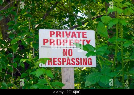 Proprietà privata No Trespassing segno con alberi intorno ad esso. Foto Stock