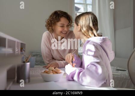 Madre felice e figlia adolescente fare insieme lavoro Foto Stock