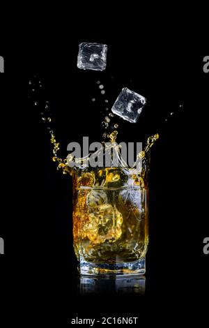 Bicchiere di whisky o altro alcool con cubetti di ghiaccio isolati su sfondo nero Foto Stock