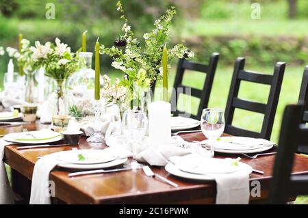 Decorazione di tavola da matrimonio con vasi di cristallo, fiori e rami Foto Stock