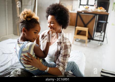 Felice madre giocare, divertirsi, abbracciando con sua figlia a casa Foto Stock