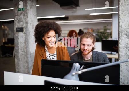 Lavorando insieme sul progetto. Felice giovani colleghi di lavoro lavoro in ufficio Foto Stock