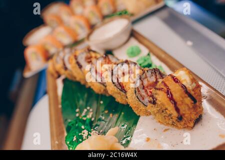 Grande set di panini al sushi caldo EBI sake Unagi Spring. Un assortimento molto di piatti Philadelphia roll da pesce crudo giapponese in un piatto in tradizionali res Foto Stock