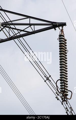 Un isolante su una torre di trasmissione altrimenti noto come pilone elettrico. Le linee ad alta tensione trasportano elettricità. Foto Stock