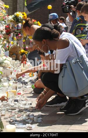 Una donna accende una candela fuori dalla Chiesa metodista di Notting Hill per i residenti della Torre di Grenfell durante il periodo successivo.UN incendio causato da un guasto elettrico in un frigorifero, scoppiato nel blocco di appartamenti della Torre di Grenfell, 24-immagazzinato, a North Kensington, Londra occidentale, dove 72 persone sono morte, oltre 70 persone sono rimaste ferite e 223 sono fuggite. Foto Stock