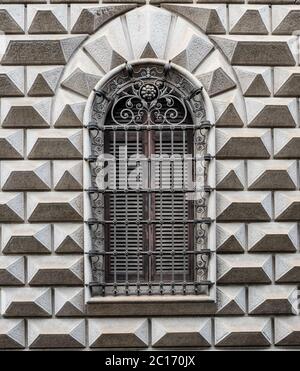 finestra ad arco di un antico castello con elegante ringhiera in ferro battuto Foto Stock