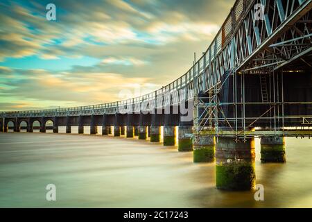 Una lunga esposizione ha livellato il movimento del fiume e sfocate le nuvole. Foto Stock