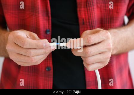 Le mani maschio collegano i fili elettrici da vicino Foto Stock